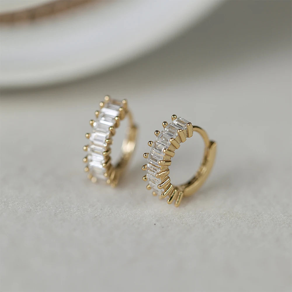 Huggie Oorbellen met Zirkonia in 18K Verguld Goud van Damaris Jewellery: Luxe oorbellen met schitterende zirkonia's, omarmd door 18K verguld goud. Een tijdloos accessoire voor elke stijlvolle gelegenheid.